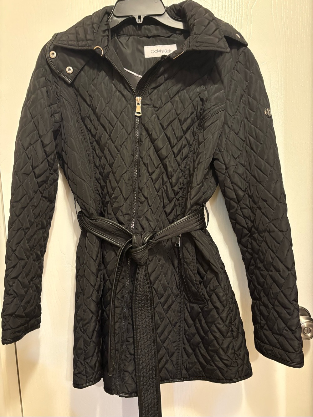 Calvin Klein puff jacket with front pockets, belt, and hood.